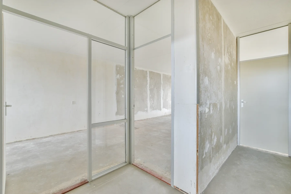 Surowe ściany działowe z aluminiowym stelażem i szklanym panelem przed malowaniem